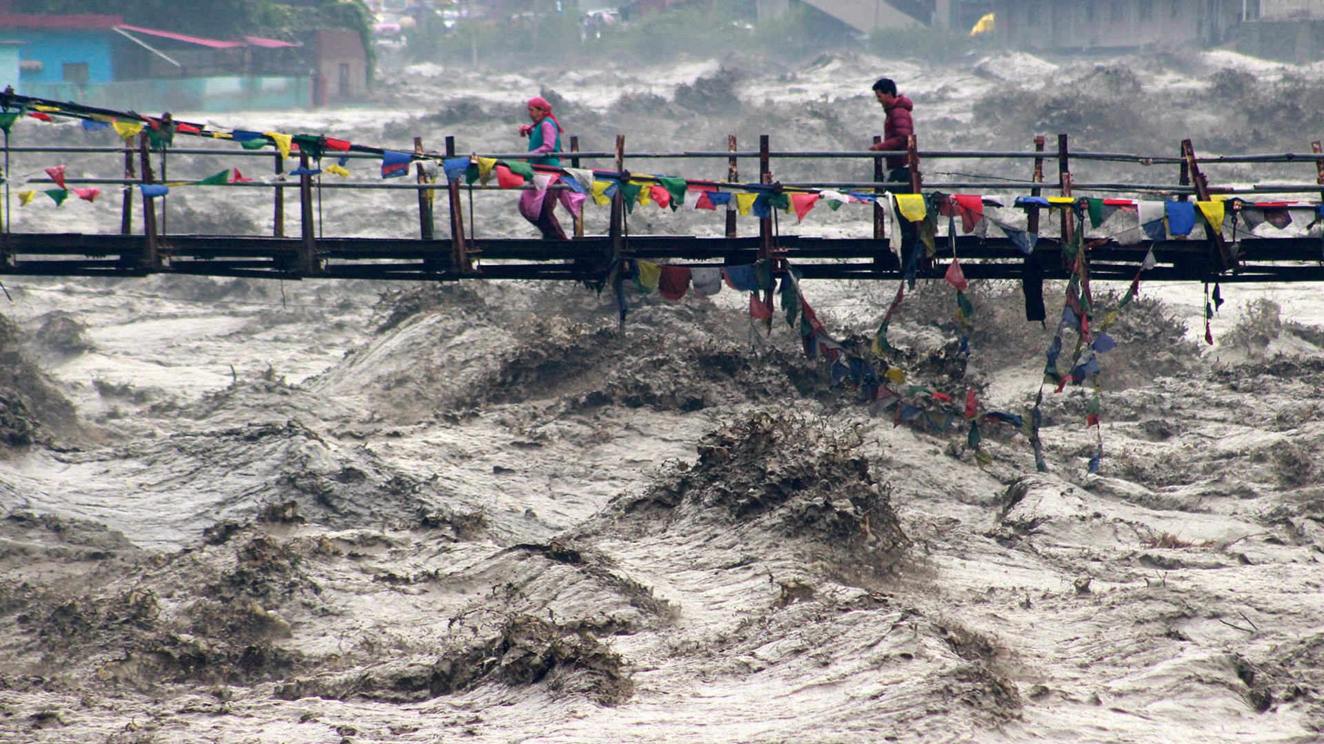 Building collapses into overflowing river during India floods