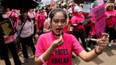 Hundreds of women with brooms join protests as Indonesia leader flies to China