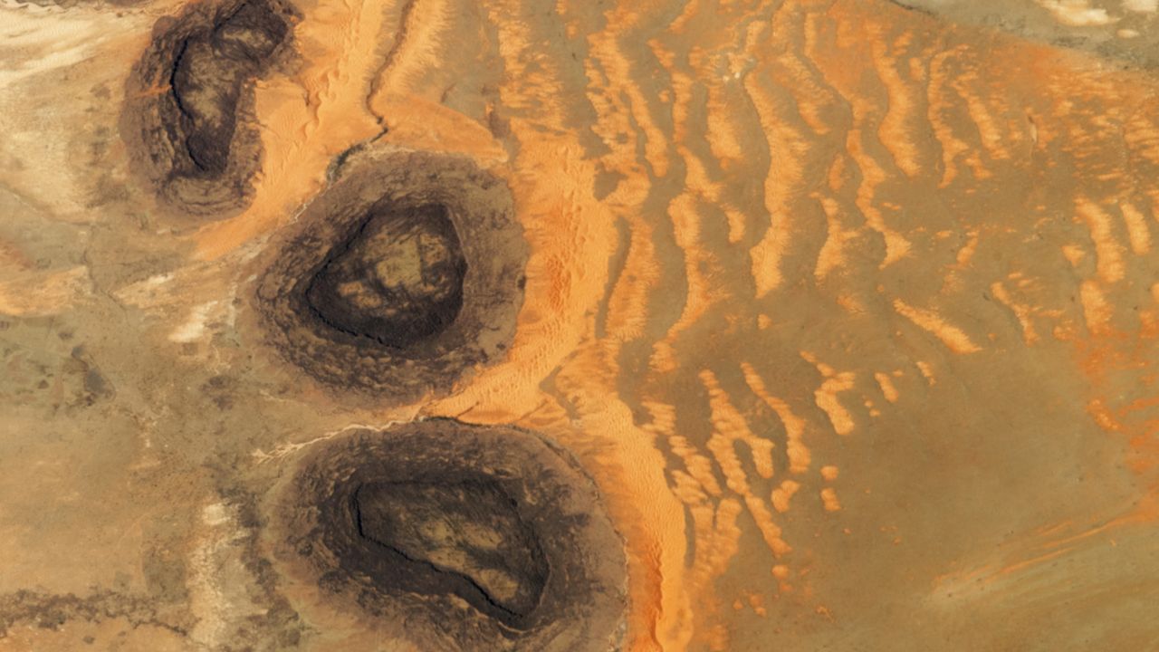 Trio of ‘black mesas’ leftover from Paleozoic era spawn rare sand dunes in the Sahara — Earth from space