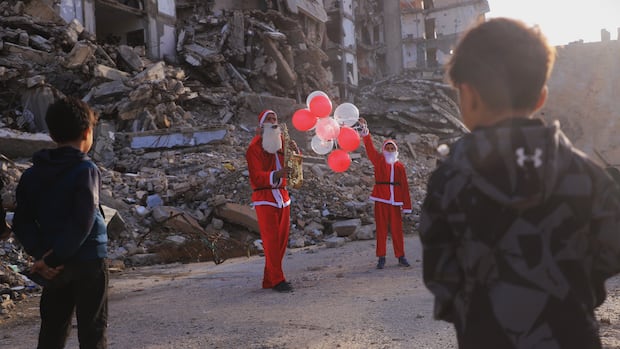 Father and son dress as Santa, visit Gaza tent city with gifts, music to celebrate New Year