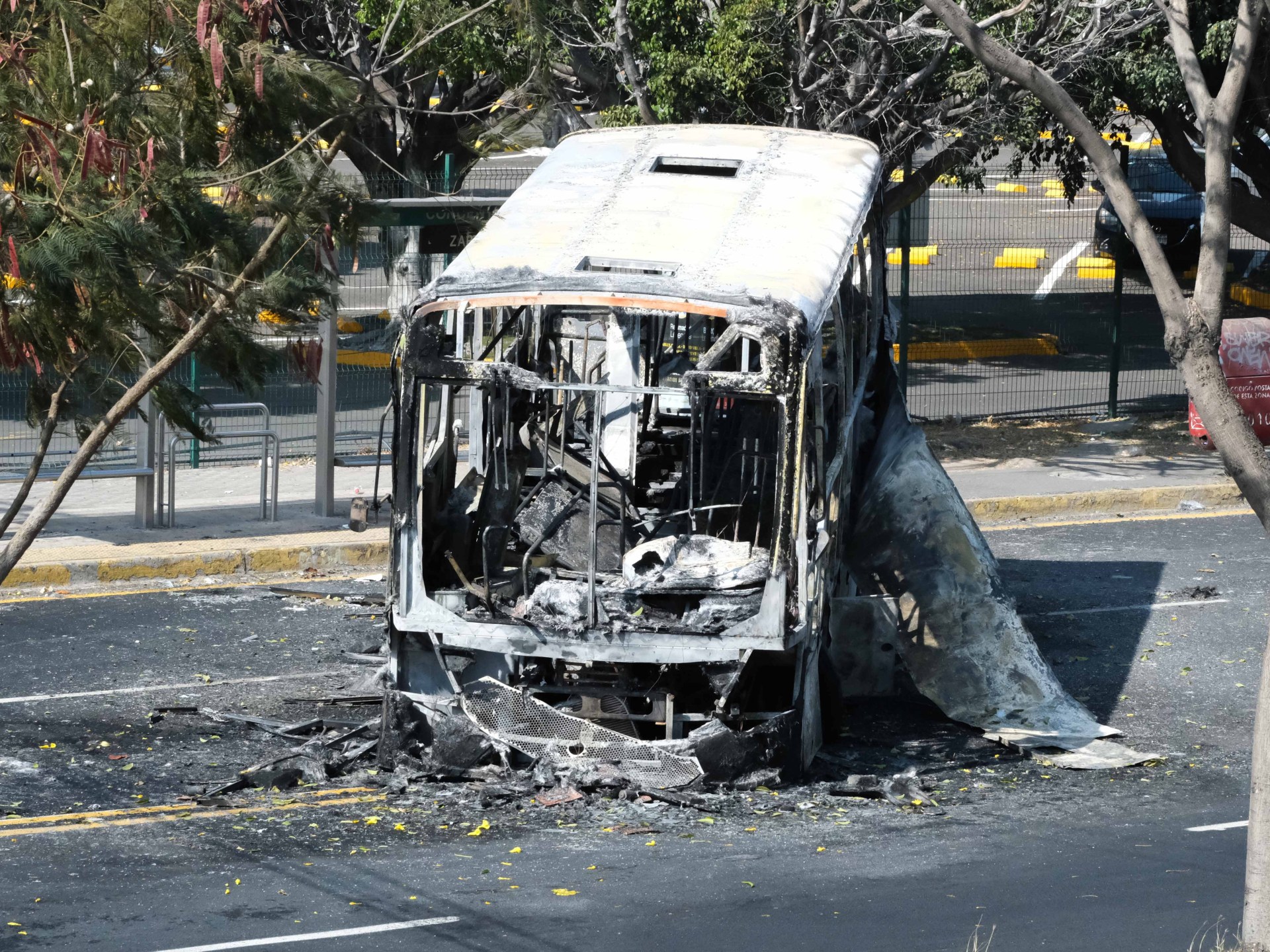Burnt vehicles line highway near Mexican World Cup stadium