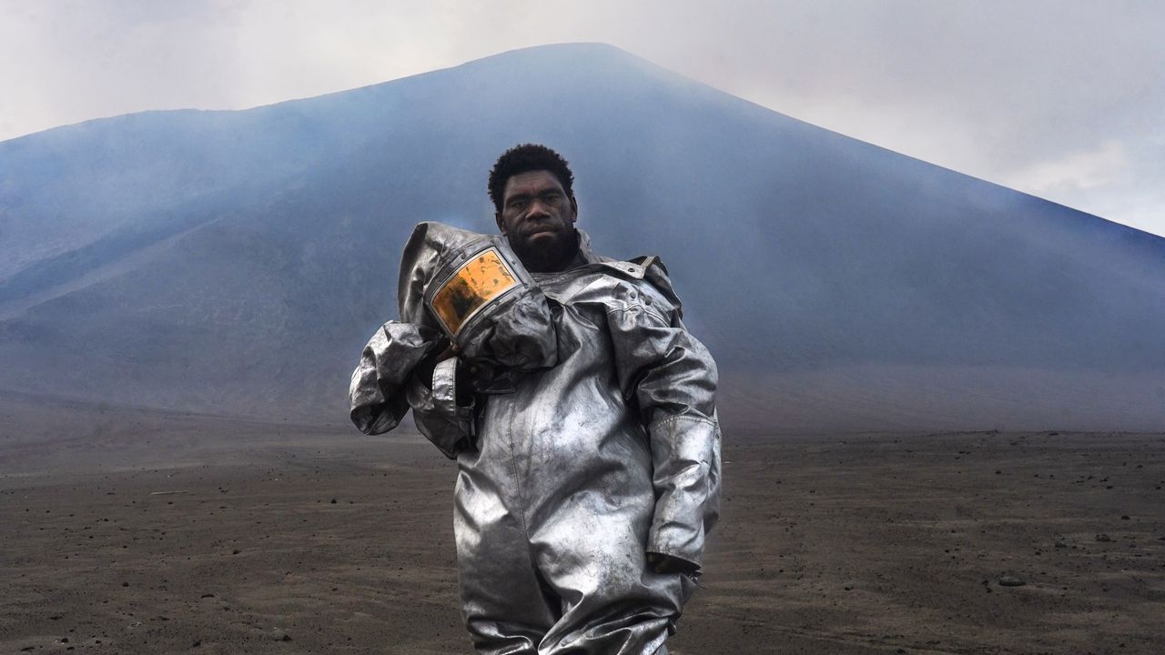 Vanuatu’s ‘barefoot volcanologist’ stands at ash- and sulfur-spewing Mount Yasur in award-winning photograph