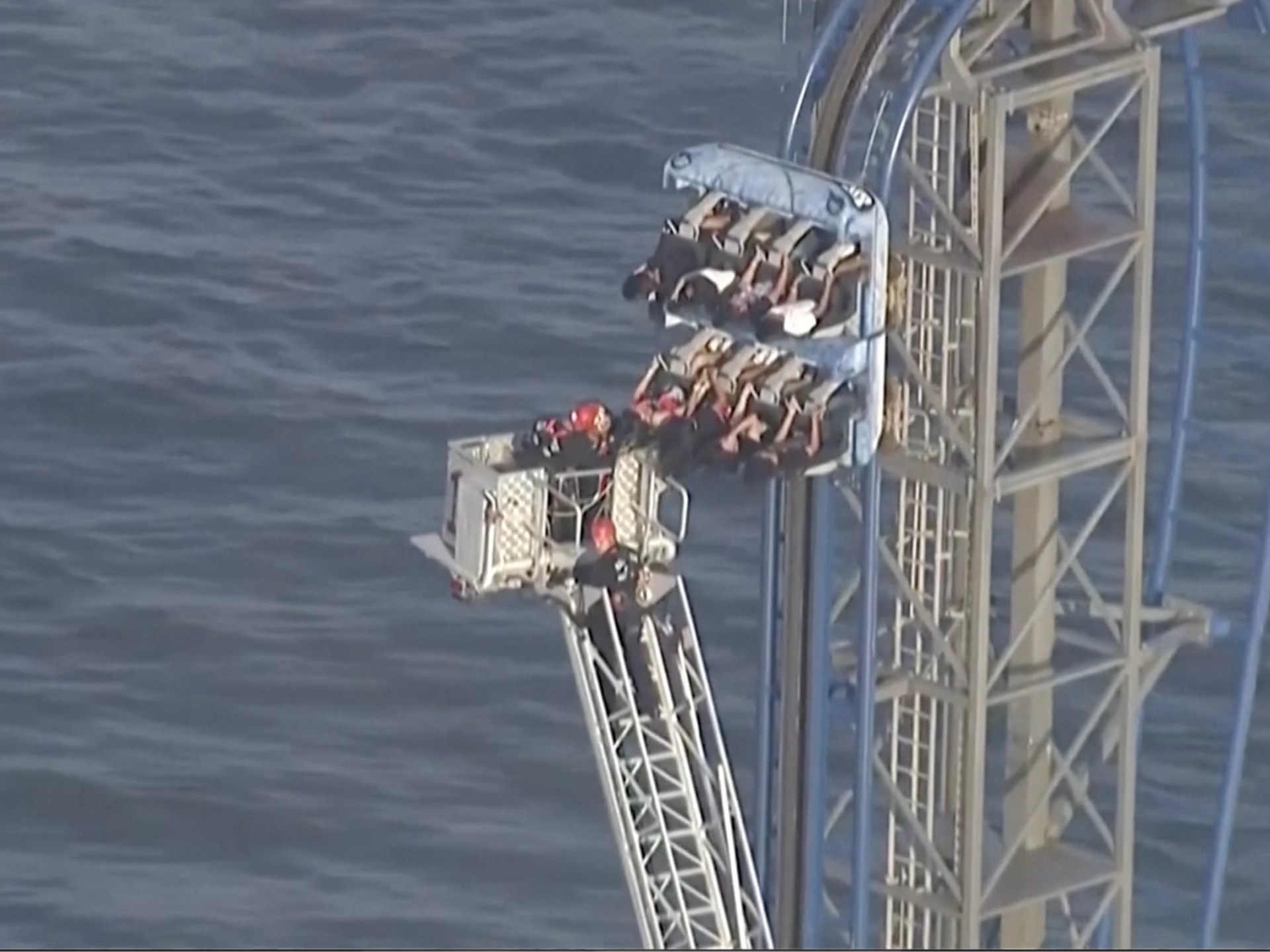 Firefighters work to free riders stuck atop a rollercoaster in Texas