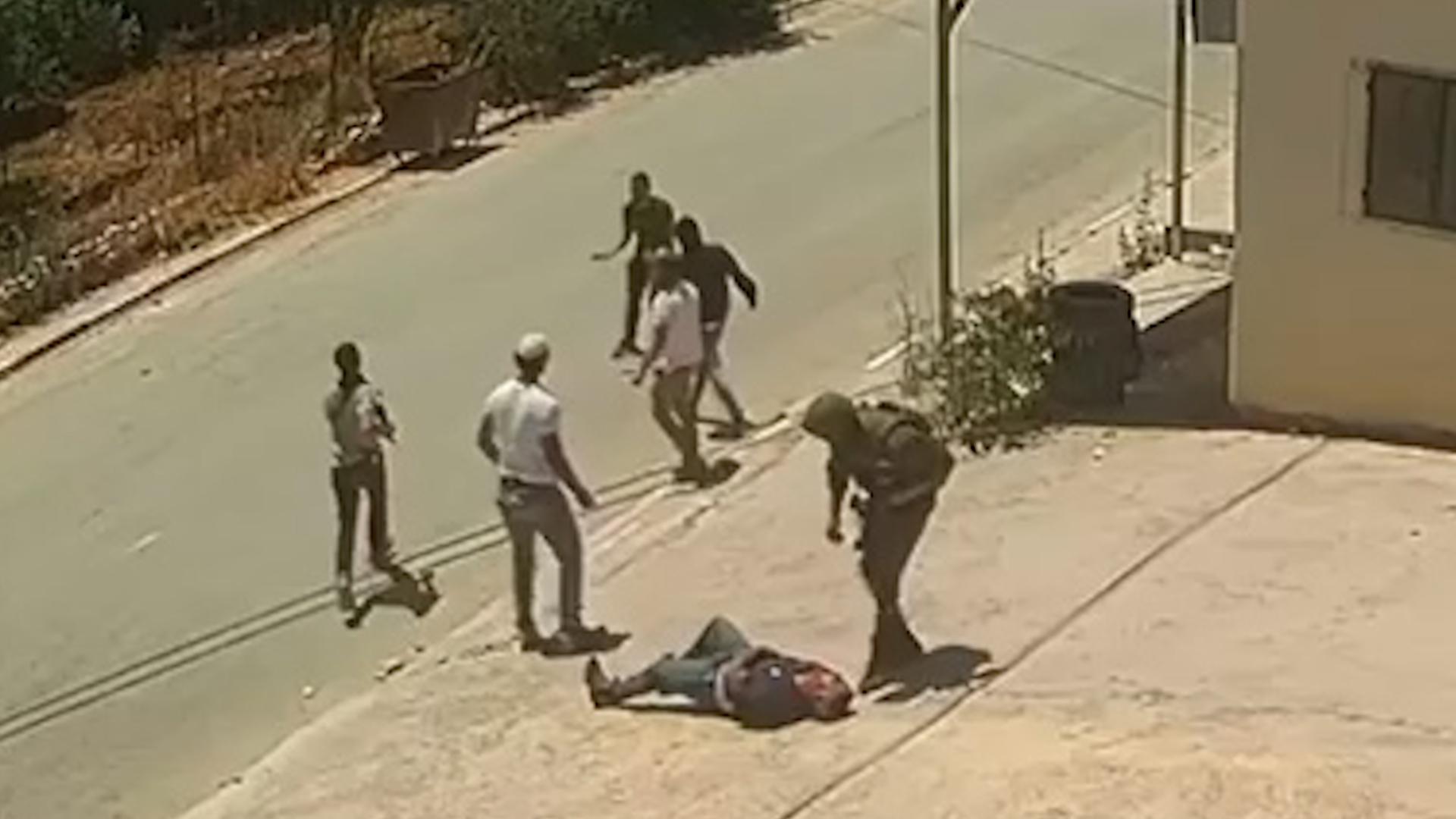 Video shows Israeli soldier and settlers assaulting two Palestinians