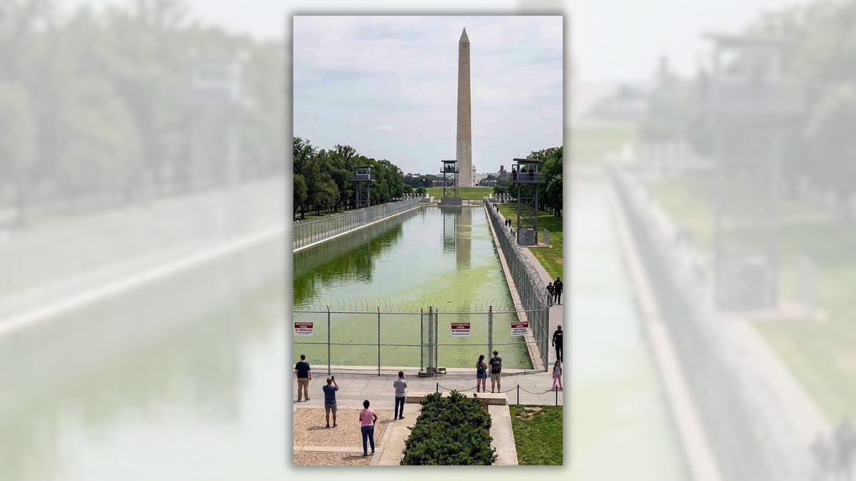 Does image show barbed wire fencing, guard towers around reflecting pool? Don’t be fooled