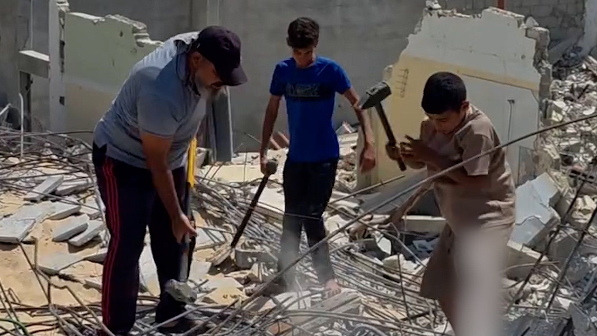 Father and sons forced to manually clear rubble in Gaza