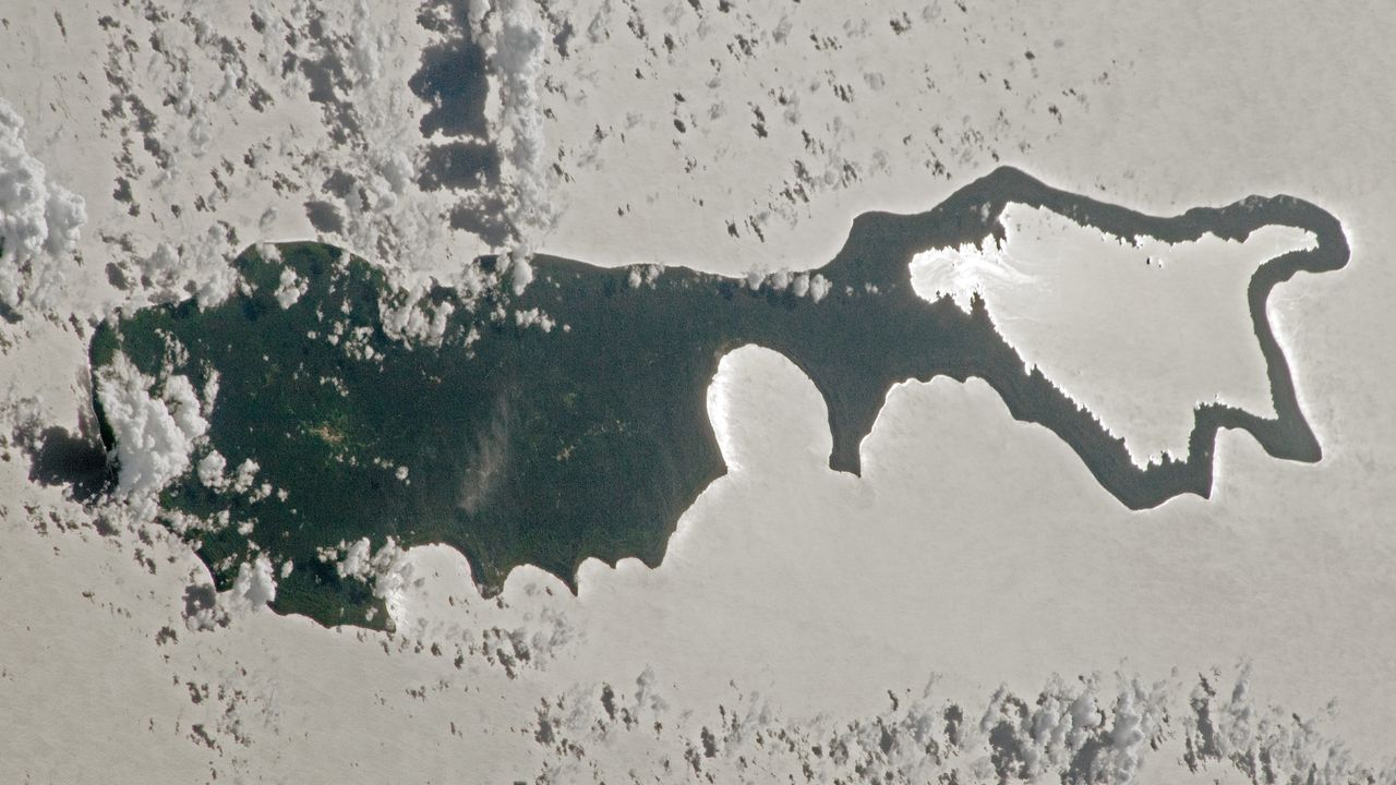 Rare sunlight trick transforms Pacific island into a giant silver ‘magnifying glass’ — Earth from space