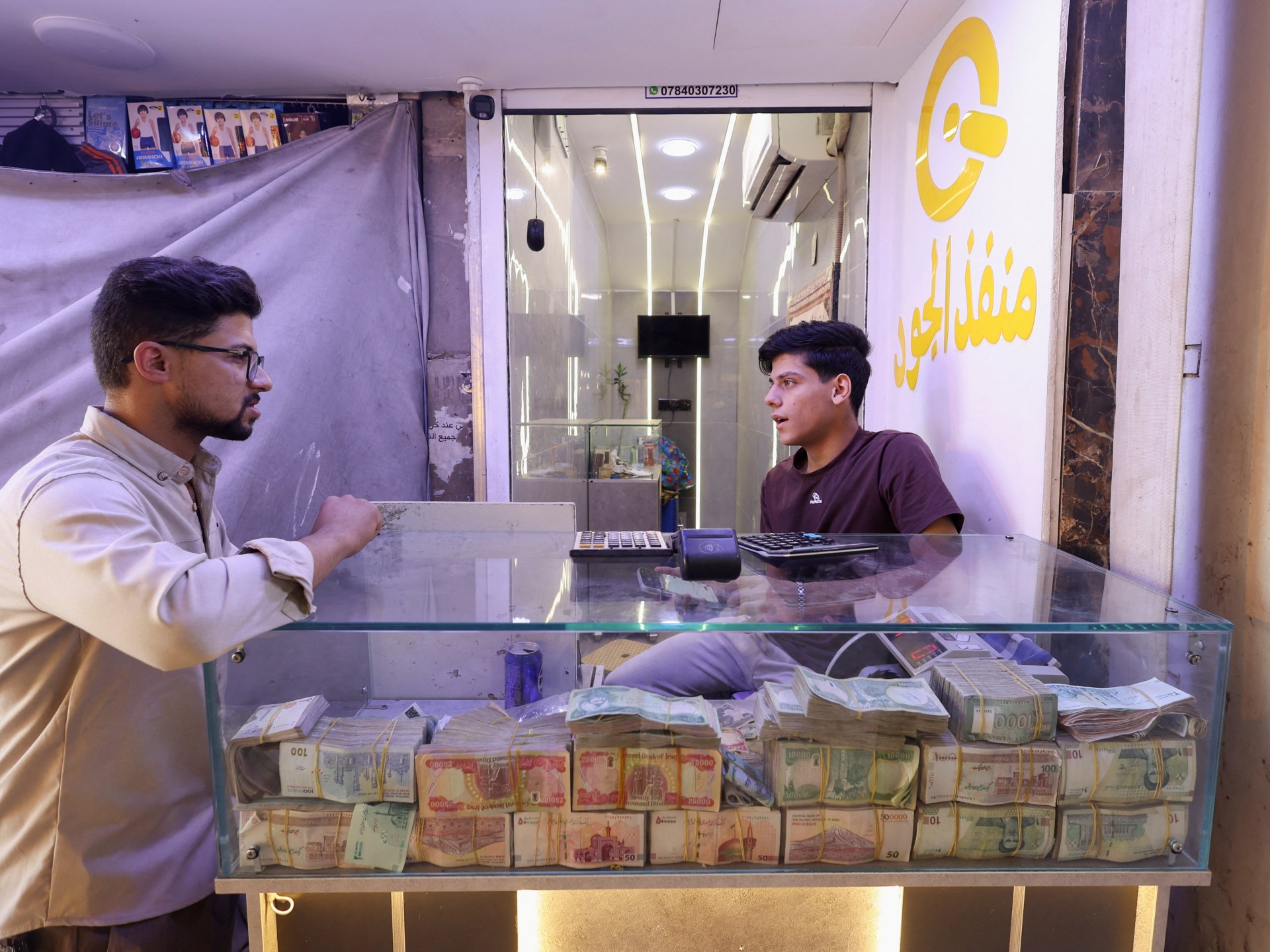 Why has Iraq devalued its currency, and why are some MPs against it?